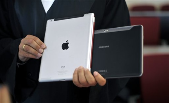 A lawyer holds an Apple iPad and a Samsung Tablet-PC at a court in Duesseldorf, Germany.